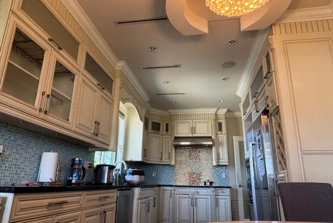 Spacious 3BR/3BA Upper Floor House for Rent in Richmond West Cambie 列治文西甘比區優質獨立屋二層 3 房 3 衛整層出租 | Selling & Managing Vancouver Real Estate Bright kitchen with white raised-panel cabinets, glass-front doors, stainless appliances, and a blue mosaic tile backsplash beneath a decorative ceiling light.